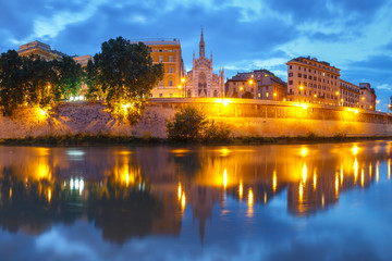 Fototapeta na wymiar Tiber riverside with Church of the Sacred Heart of Jesus in Prati and mirror reflection during evening blue hour in Rome, Italy