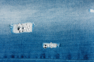 Luxurious, stylish background of torn jeans inlaid with rhinestones. Texture. - 162057950