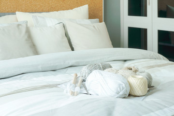 Fototapeta na wymiar Knitting wool and needle on bed in modern interior bedroom