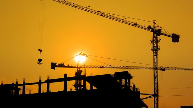 Silhouette Crane Working In Construction Site 4K Time Lapse