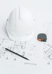architects workplace - architectural blueprints with measuring tape, safety helmet and tools on table. top view