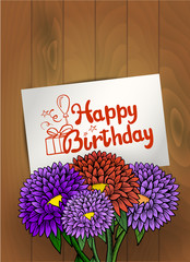 Bouquet of flowers with birthday greeting card. Wood background