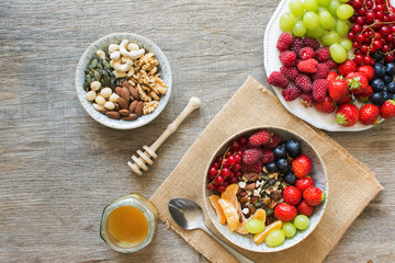 Paleo style breakfast, grain free muesli made with nuts and dried fruits, served with fresh berries, top view, selective focus