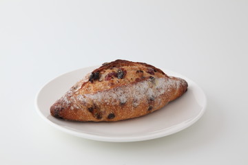 お皿にのせたフランスのパン クランベリーとチョコチップ バゲット 白背景