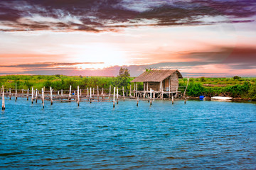 Naklejka premium Hut in a Beautiful Scene with Water, Land, Sky