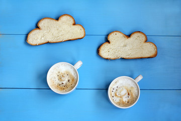 coffee rain in clouds of toast/ Flat layout with frothy cappuccino in cups and white bread on a blue table