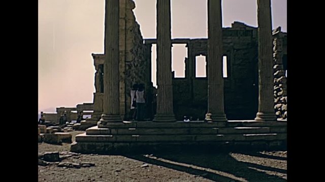 Tourists at ruins of Erechtheion or Erechtheum and Ancient Greek temple on north side of the Acropolis of Athens in Greece. Dedicated to Athena and Poseidon gods. Restored 70s archival footage on 1972