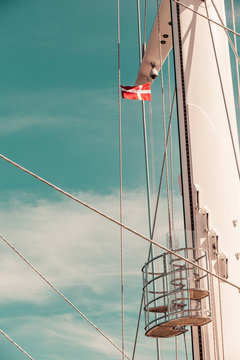 Denmark flag on ship mast, blue sky in background