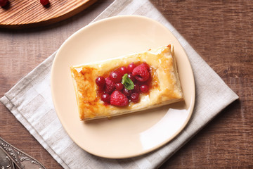 Plate with delicious puff and berries, top view