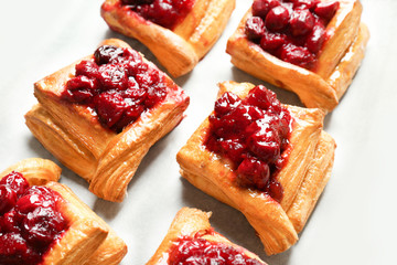 Tray with delicious puff pastries and cherry, closeup