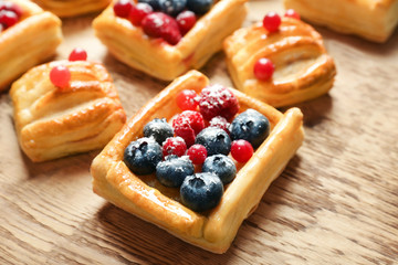 Delicious pastries with berries on wooden table
