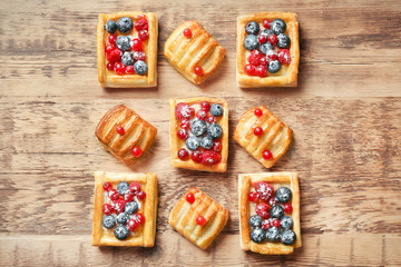 Delicious pastries with berries on wooden table