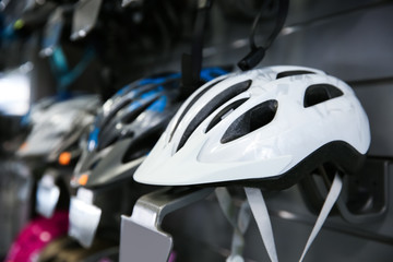 Fototapeta premium Bicycle helmets on shelves in sport shop