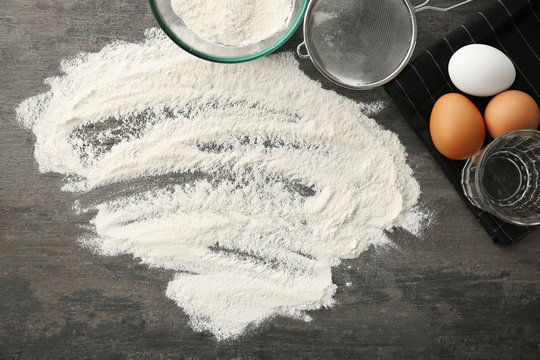 Sprinkled flour and kitchenware on grey table