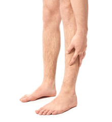 Young man suffering from pain in leg on white background