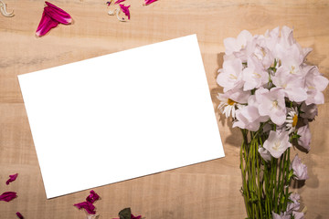 White sheet of paper with a bouquet of flowers lying on a table