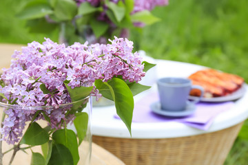 Beautiful lilac flowers on table outdoors