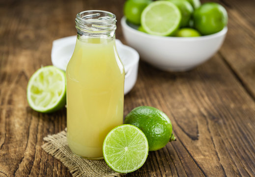 Fresh Lime Juice on wooden background (selective focus)
