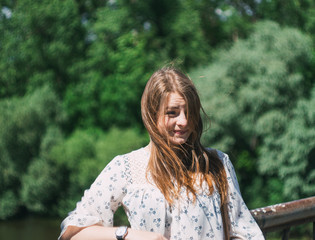 the girl's brunette hair fly in the wind. beautiful long hair. portrait outdoor on the nature of the tint