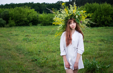 Beautiful girl in wreath of wild flowers. Holiday of Ivan Kupala.