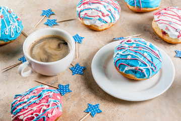 Food for independence day. 4th of July. Festive breakfast: traditional American donuts with glaze in colors of USA flag blue, red, white. Cup of coffee. On light stone table. Copy space