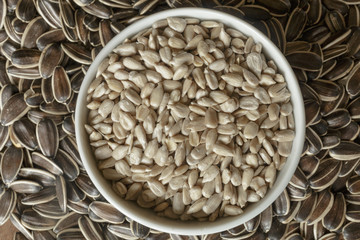 Dried unshelled sunflower seeds on a wooden table. Vegetarian food