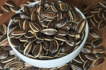 Dried unshelled sunflower seeds on a wooden table. Vegetarian food
