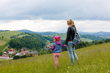 mom and little daughter traveling in the mountains