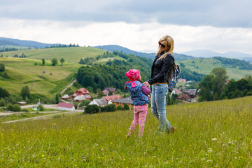 Fototapeta premium mom and little daughter traveling in the mountains