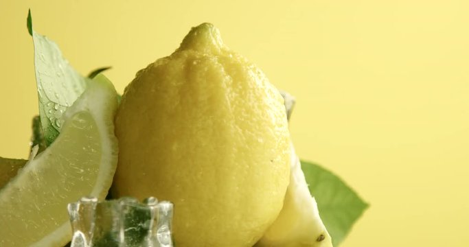 composition of lemons, leaves and ice cubes. Covered by water drops. Fresh summer fruit composition