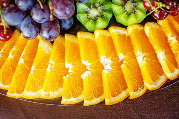 A set of fruits with oranges, kiwi, grapes and sweet cherries. The concept of healthy food and vegetarian.