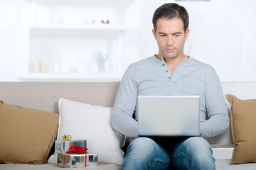 man with laptop on sofa at home