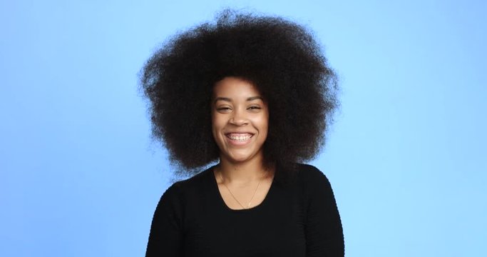 beuayt black woman with a huge afro hair having fun smiling and touching her hair