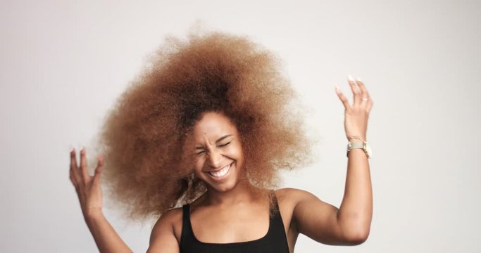 beuayt black woman with a huge afro hair having fun smiling and dancing