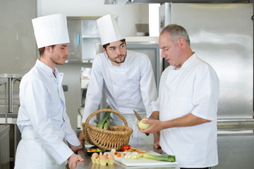 teacher helping students training to work in catering