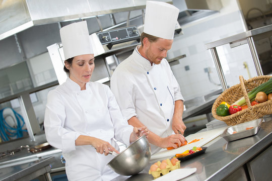 male cooks preparing dishes in restaurant kitchen
