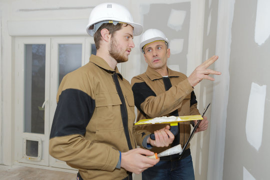 construction worker wearing worker overall with wall plastering tools