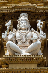 Nanjangud, India - October 26, 2013: Closeup of white statue of Shiva as Adi Yogi on the beige Gopuram of Srikanteshwara Temple.