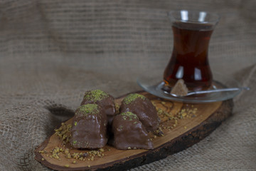 Chocolate Baklava with Pistachio Presentation on A Wooden Plate with Turkish Tea