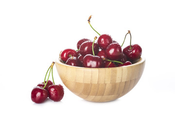 Cuenco de madera con cerezas frescas, fruta roja para una comida saludable aisladas sobre fondo blanco.