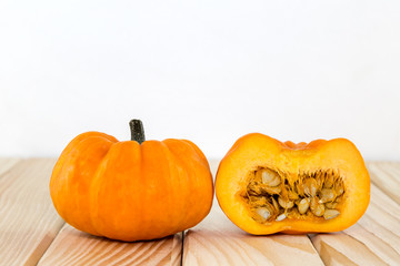 Ein aufgeschnittener Kürbis liegt auf Holzbrettern