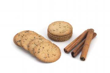 Biscuits and cinnamon sticks on white background