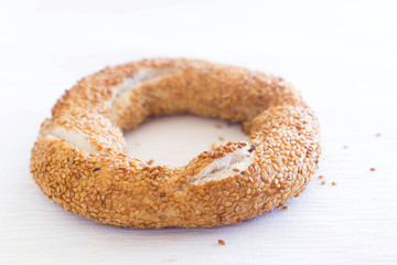 Fototapeta na wymiar One bagel with sesam seeds on white background