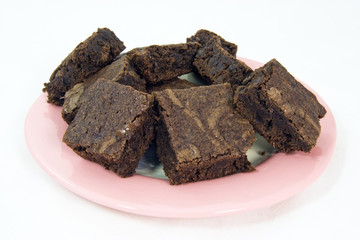 Homemade brownies on a pink plate.