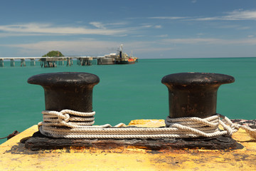 Black old bollard with ropes