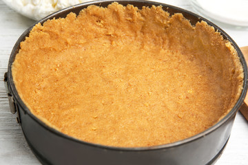 Baking form with base for cheesecake on table