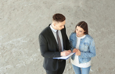 Insurance adjuster and beautiful woman in abandoned building