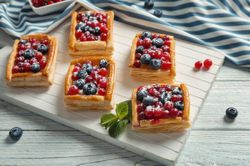 Delicious pastries on white wooden cutting board