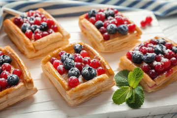 Delicious pastries on white wooden cutting board