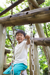 Obraz premium 公園の遊具で遊ぶ男の子 夏休み